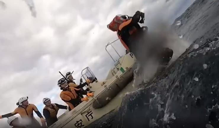 יפן חילוץ בלב ים של גבר ב סירה שהתהפכה