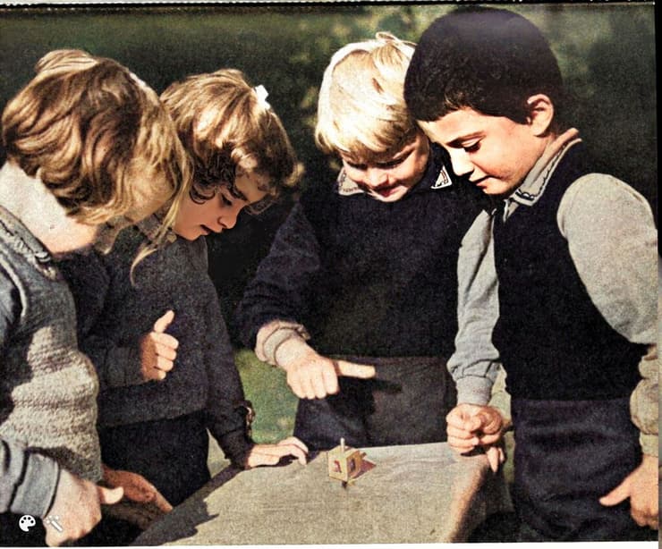 ילדים משחקים בסביבון על גבי שולחן, חנוכה 1942