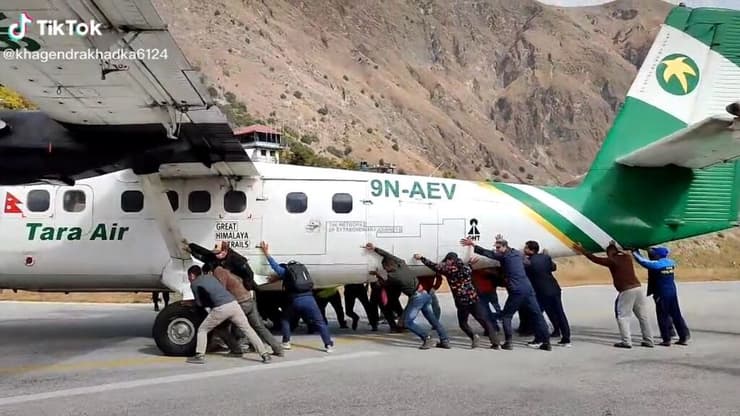 נוסעים דוחפים מטוס של חברת טארה אייר שנתקל על המסלול בנפאל
