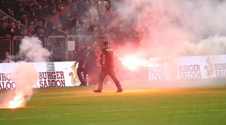 מאבטח מפנה את האבוקה שנזרקה לדשא