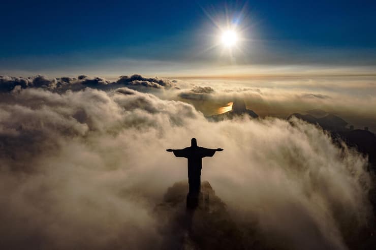 תמונות השנה של AFP שנת 2021 השמש זורחת על פסל ישו ריו דה ז'ניירו 90 שנה להצבת הפסל 24 במרץ