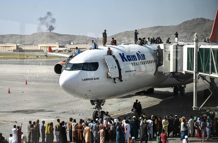 תמונות השנה של AFP שנת 2021 אפגנים על מטוס ב נמל התעופה ב קאבול מחכים לברוח אחרי עליית ה טליבאן 16 אוגוסט
