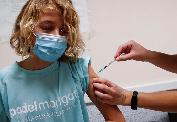 ילד בן 11 מתחסן חיסון נגד קורונה ב ברצלונה ספרד 