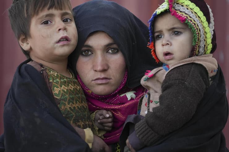 אמא מחזיקה את הילדים יישוב לעקורים אפגניסטן