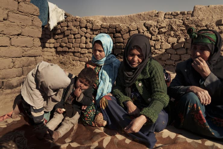 עזיז שנייה מימין עם בתה קאנדי אפגניסטן הורים מוכרים את הילדים