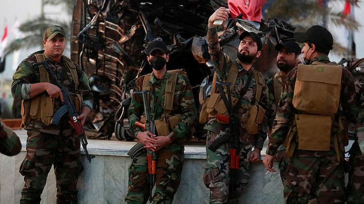 לוחמים במיליציות הפרו איראניות ליד הרכב של קאסם סולימאני שדה התעופה בגדד עיראק