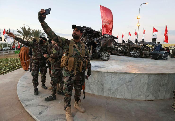 לוחמים במיליציות הפרו איראניות ליד הרכב של קאסם סולימאני שדה התעופה בגדד עיראק
