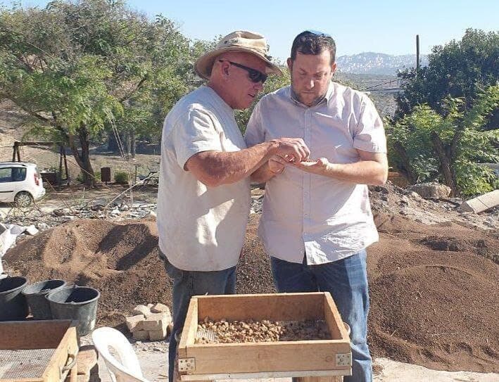 צבי קניגסברג מראה לראש מועצת שומרון את הקמע לאחר הסינון