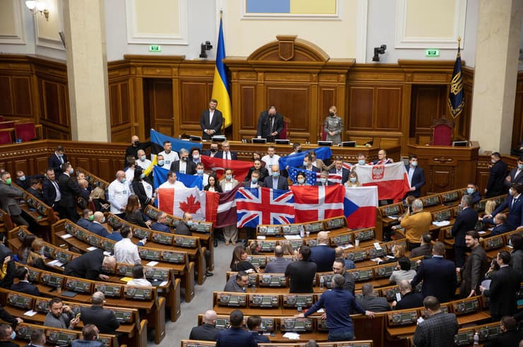 מחוקקים בפרלמנט באוקראינה קייב מניפים דגלים של מדינות המערב