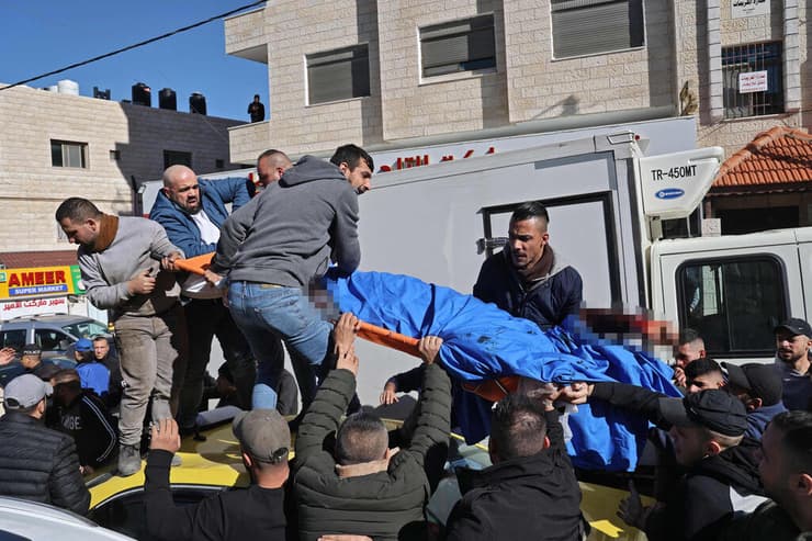 פלסטינים מוציאים את גופתו של אחד מתוך שלושת המחבלים שחוסלו בשכם