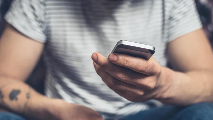 גבר עם סמארטפון ושלט רחוק