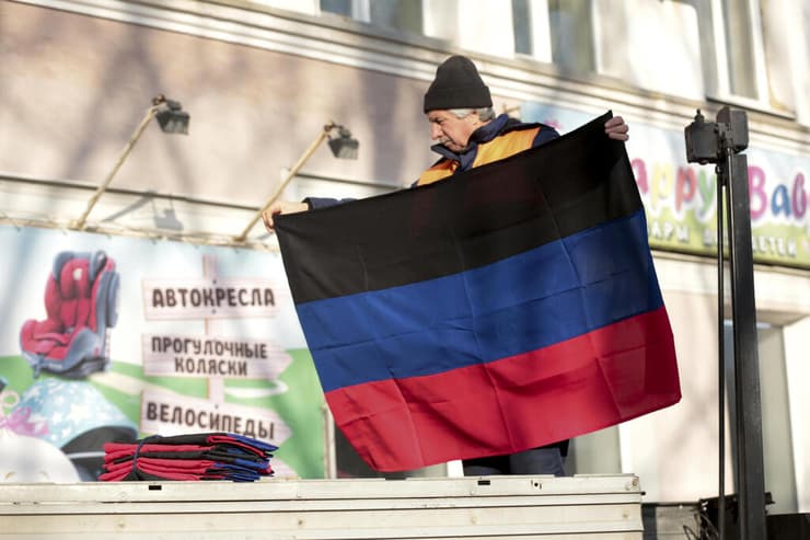 תולים את דגל הרפובליקה העממית של דונייצק על בניין בעיר ב מזרח אוקראינה