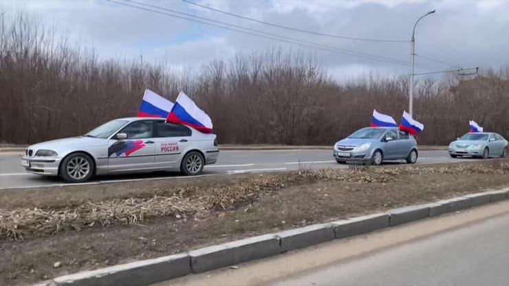 שיירה רכבים עם דגלי רוסיה נוסעת ב דונייצק