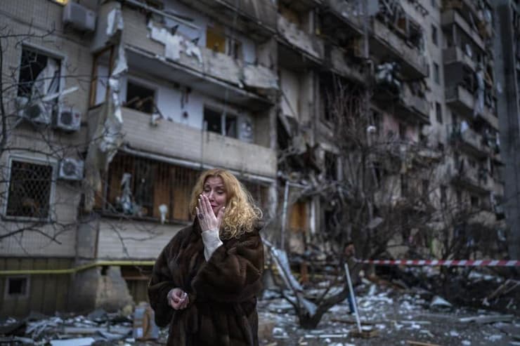 אישה לצד הריסות ביתה שנפגע במתקפת טילים בקייב, אוקראינה