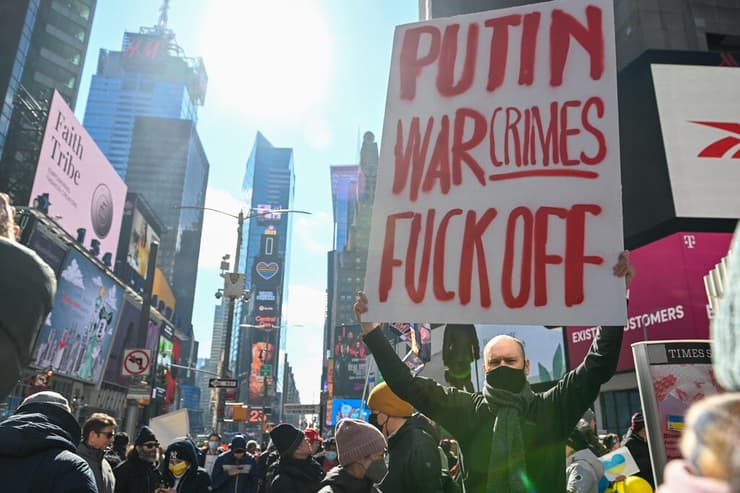 איש אוחז בשלט נגד פוטין בטיימס סקוור ניו יורק 