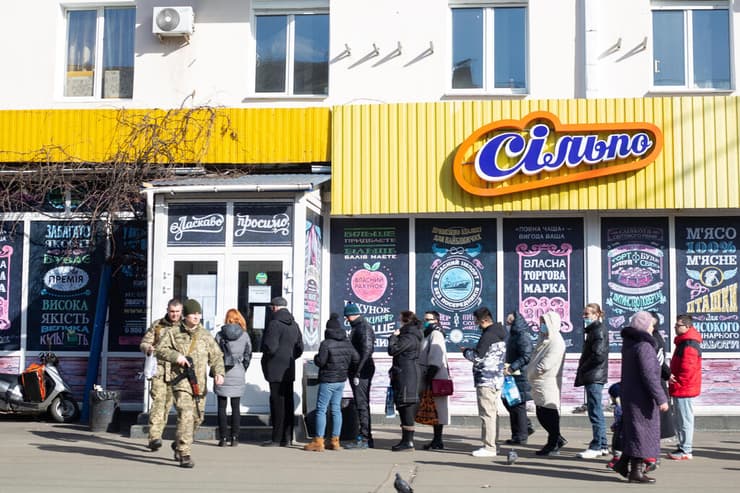 קייב אוקראינה אזרחים ממתינים ב תור ל  מכולותסופר סופרים ריק ריקים אין אוכל חנות מזון בעקבות מלחמה פלישה עם רוסיה משבר  