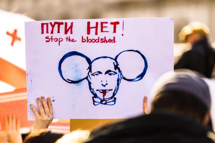 שלטים נגד ולדימיר פוטין נשיא רוסיה ב הפגנה נגד הפלישה ל אוקראינה ב לונדון בריטניה