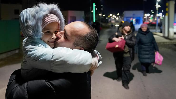 אב מנשק את בתו, שיצאה מאוקראינה יחד עם אמה