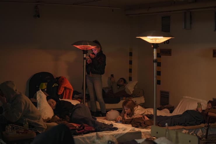 תושבי קייב שוכבים על מזרונים בחניון תת קרקעי של מלון שהפך למקלט