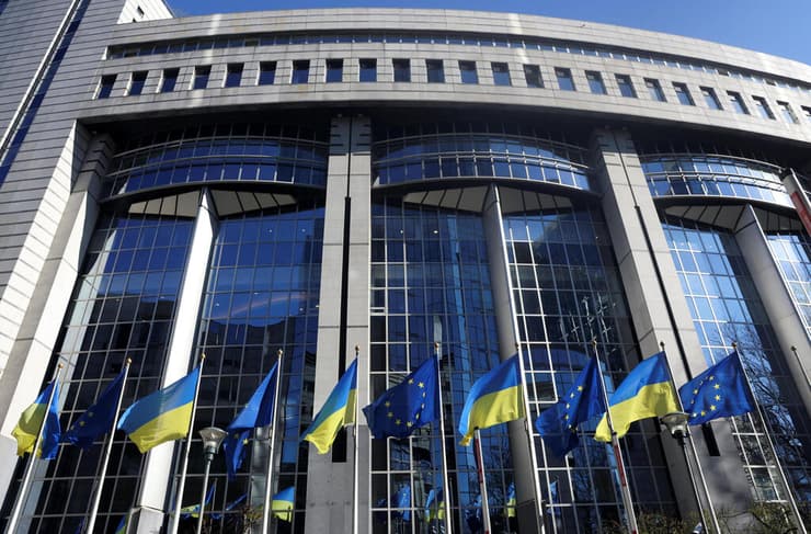 דגלי אוקראינה והאיחוד האירופי ליד בניין הפרלמנט של האיחוד האירופי בבריסל