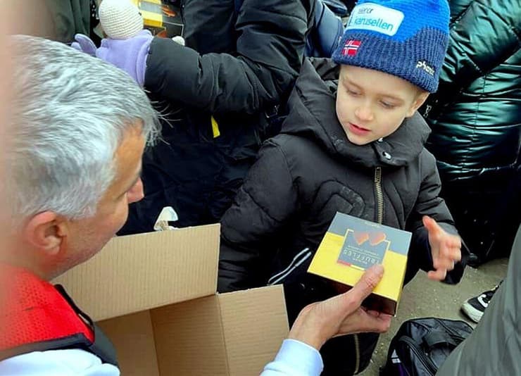 מנכ"ל העמותה נותן שוקולד לאחד מילדי הפליטים
