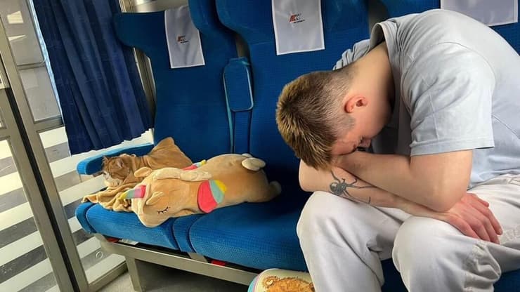 פליט אוקראיני והחתול שלו ברכבת בדרך לגרמניה