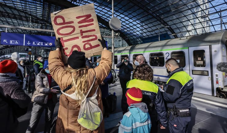 מתנדבים ממתינים ל פליטים מ אוקראינה שיגיעו ל תחנת ה רכבת ה מרכזית ב ברלין גרמניה