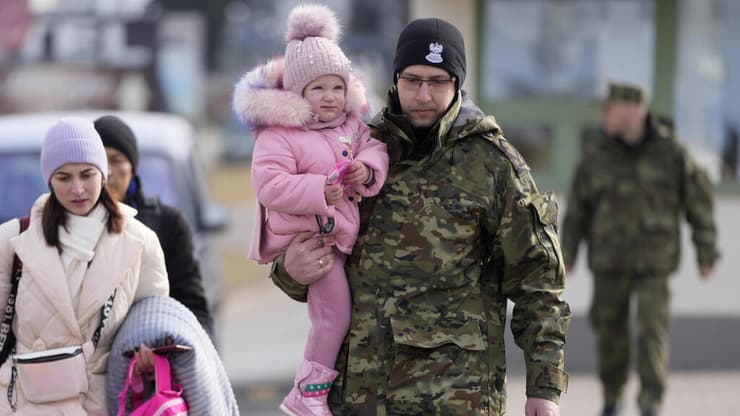 חייל פלוני נושא ילדה פליטה מאוקראינה בפולין