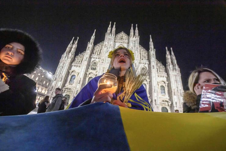 מילאנו איטליה - מפגינים מחזיקים דגל אוקראינה ענק במהלך הפגנה נגד התוקפנות הרוסית במילאנו   אוקראינה רוסיה משבר מלחמה 