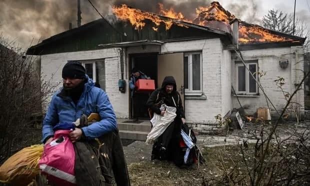 אוקראינים מחלצים חפצים מבית עולה באש באירפין, אוקראינה