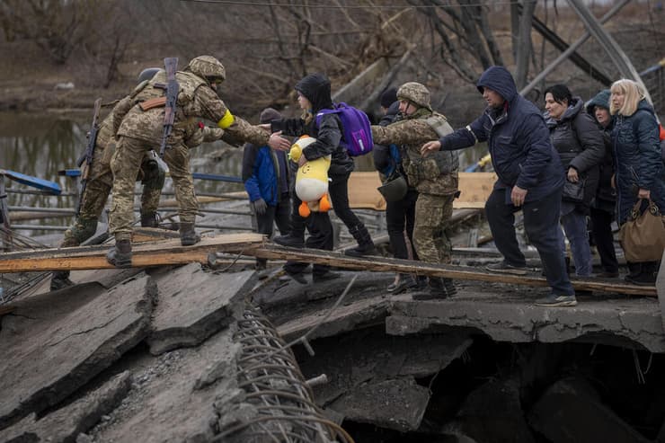 חיילים אוקראינים עוזרים ל משפחה ילדים לחצות את נהר אירפין סמוך ל קייב אוקראינה מלחמה באירופה משבר