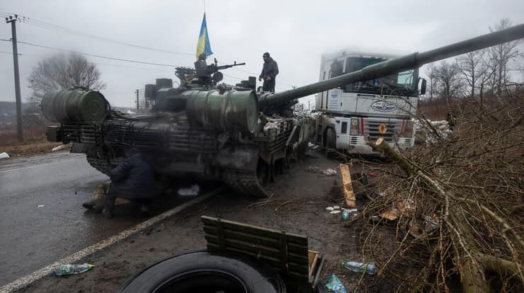 חייל אוקראיני ליד כלי רכב של צבא רוסיה שנפתסו באזור חרקוב