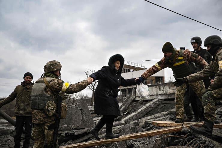 חייל חיילים של צבא אוקראינה מסייעים למשפחה של פליטים פליט לחצות את נהר אירפין סמוך ל קייב מלחמה עם רוסיה