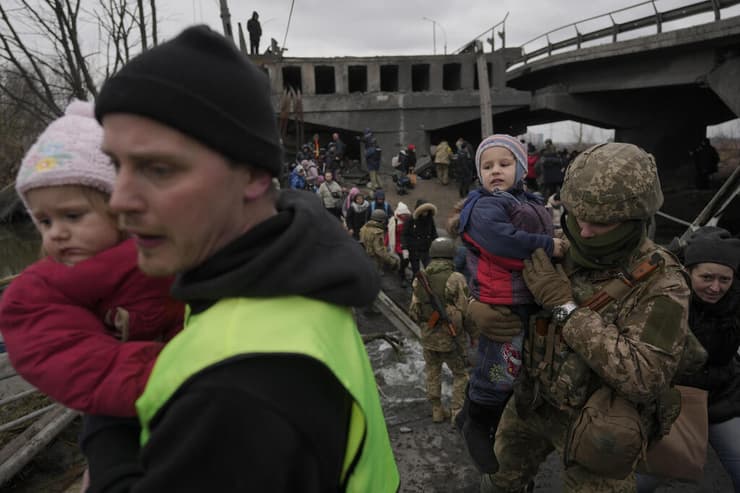 חייל חיילים של צבא אוקראינה מסייעים ל משפחה אנשים אוקראינים לחצות את נהר אירפין גשר נהרס סמוך ל קייב מלחמה עם רוסיה
