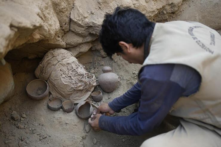 איתור שרידי ילד חנוט, עטוף בבד, שאותר באתר הארכיאולוגי קאג'מרקילה בפרו 