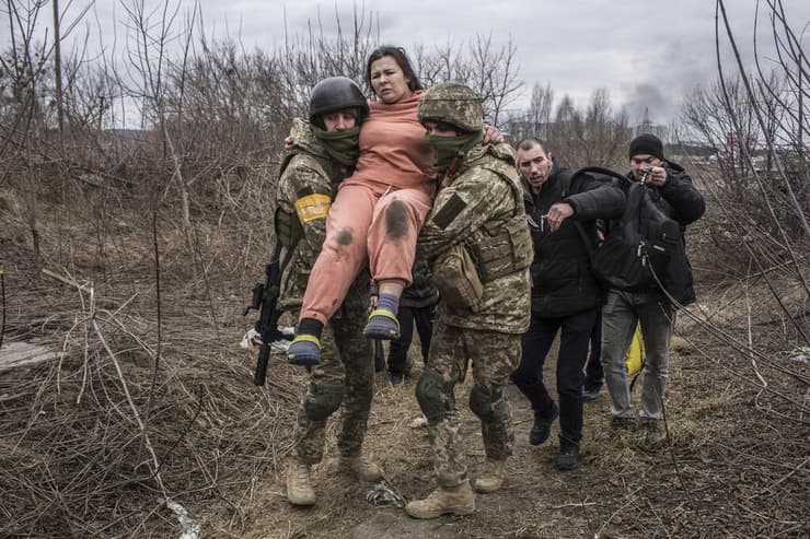 אירפין אוקראינה אישה נישאת על ידי חיילים אוקראינים חוצה שביל מאולתר ב זמן ש היא בורחת מ העיירה אירפין אוקראינה משבר מלחמה רוסיה 