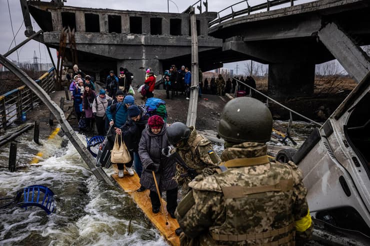 מפונים פליטים  חוצים גשר הרוס כש הם בורחים מ העיר אירפין צפונית-מערבית לקייב משבר מלחמה רוסיה אוקראינה 