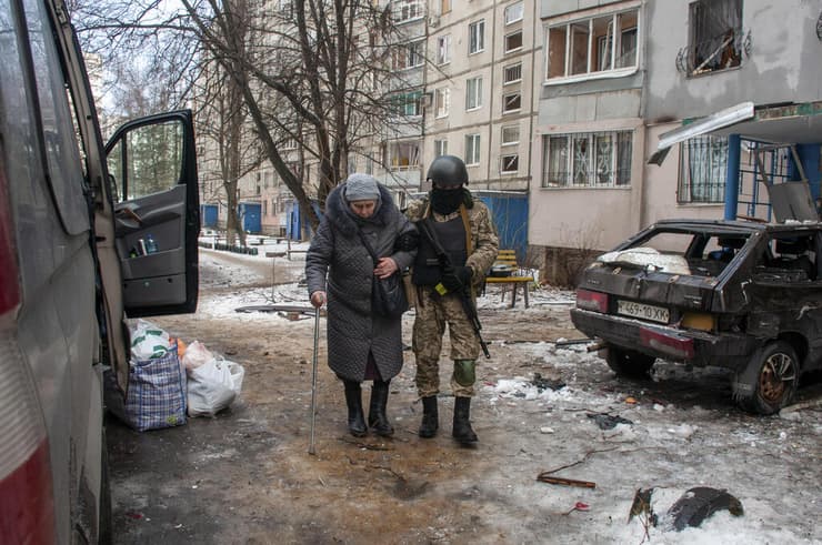 חייל אוקראיני עוזר ל קשישה לעזוב בניין מבנה מגורים שנהרס הרס הפגזות ב חרקוב אוקראינה צבא מלחמה באירופה