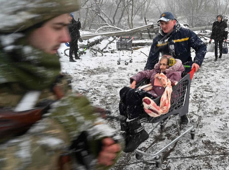 חיילים מסייעים לקשישה לעבור את הגשר שנהרס באירפין