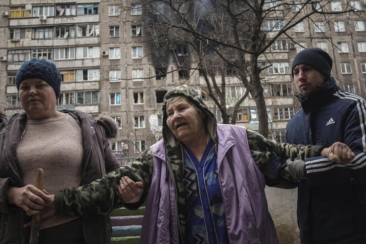 עוזרים לקשישה שדירתה נפגעה מ הפגזה של צבא רוסיה ב מריופול ב אוקראינה מלחמה 8.3