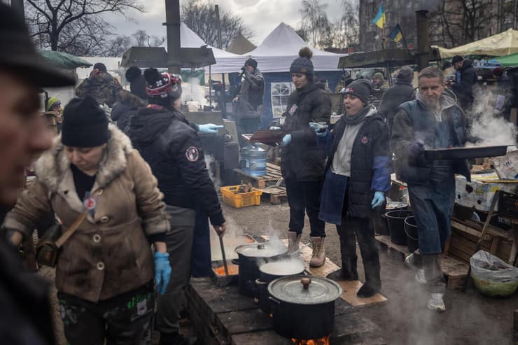 מתנדבים מכינים אוכל עבוד חיילים ואזרחים בקייב