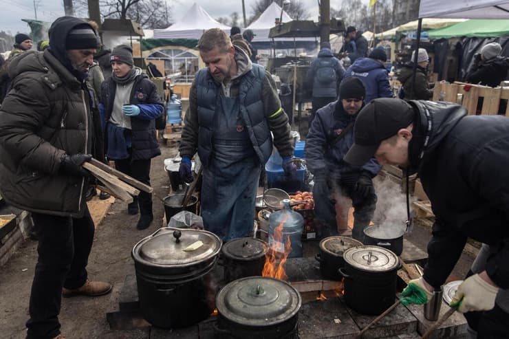 מתנדבים מכינים אוכל עבוד חיילים ואזרחים בקייב