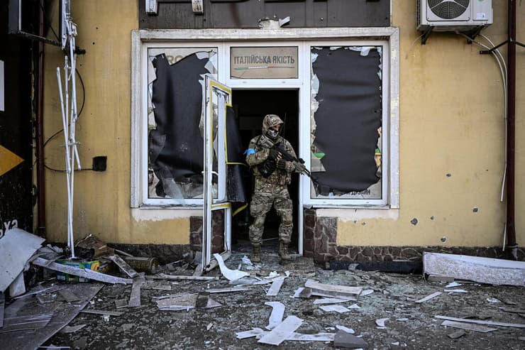 קייב חייל אוקראיני יוצא מבניין שניזוק בעקבות הפגזה משבר מלחמה רוסיה אוקראינה 