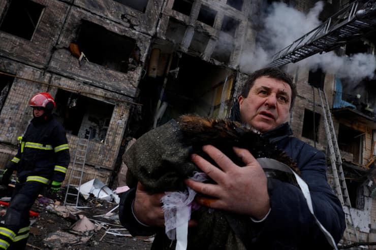  כוחות הצלה מחלצים אזרחים מ בניין בוער שנפגע מהפגזות בקייב