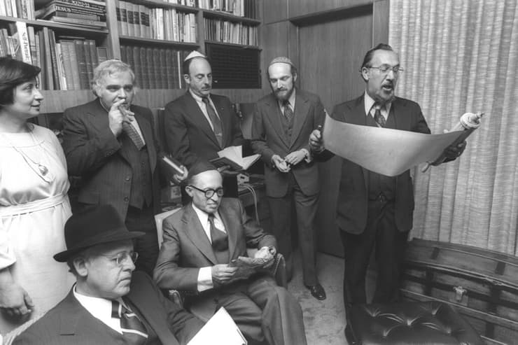 ראש הממשלה מנחם בגין יושב בכיפה שחורה בקריאת מגילה בבית שגריר ישראל בוושינגטון, שמחה דיניץ, ב-1978
