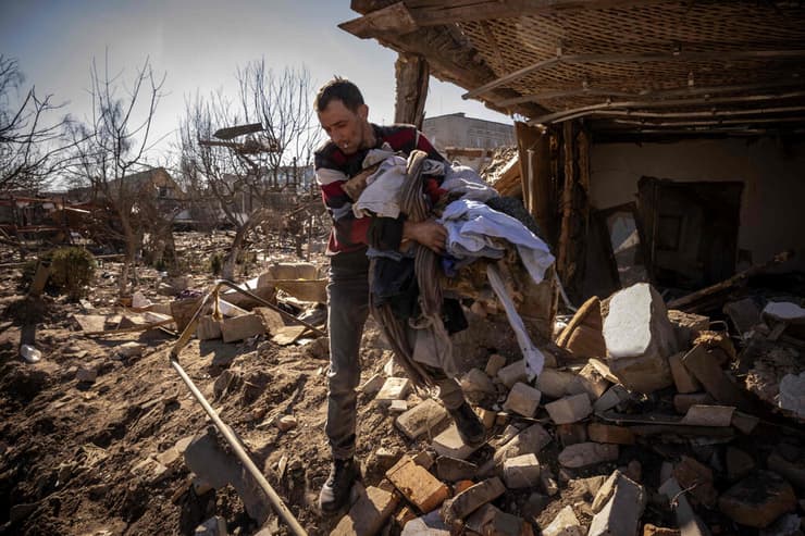 ז'יטומיר אוקראינה גבר אוסף את בגדיו מביתו שהופצץ