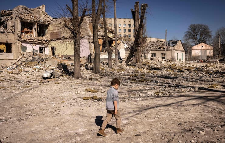 ז'יטומיר צפון אוקראינה ילד משוטט מול הריסות בית ספר ש נפגע בהפצצה משבר מלחמה רוסיה אוקראנה 