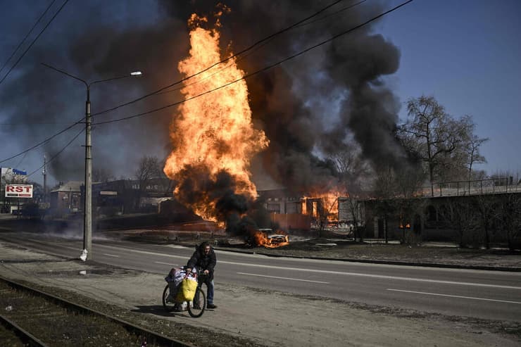 אדם נמלט בזמן שריפה כתוצאה מההפצצה הרוסית בעיר חרקוב, אוקראינה