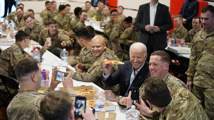 ג'ו ביידן אוכל פיצה עם חיילים אמריקאים בפולין 