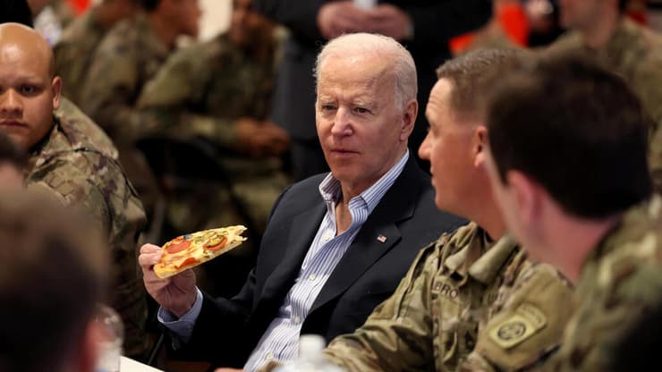ג'ו ביידן אוכל פיצה עם חיילים אמריקאים בפולין 